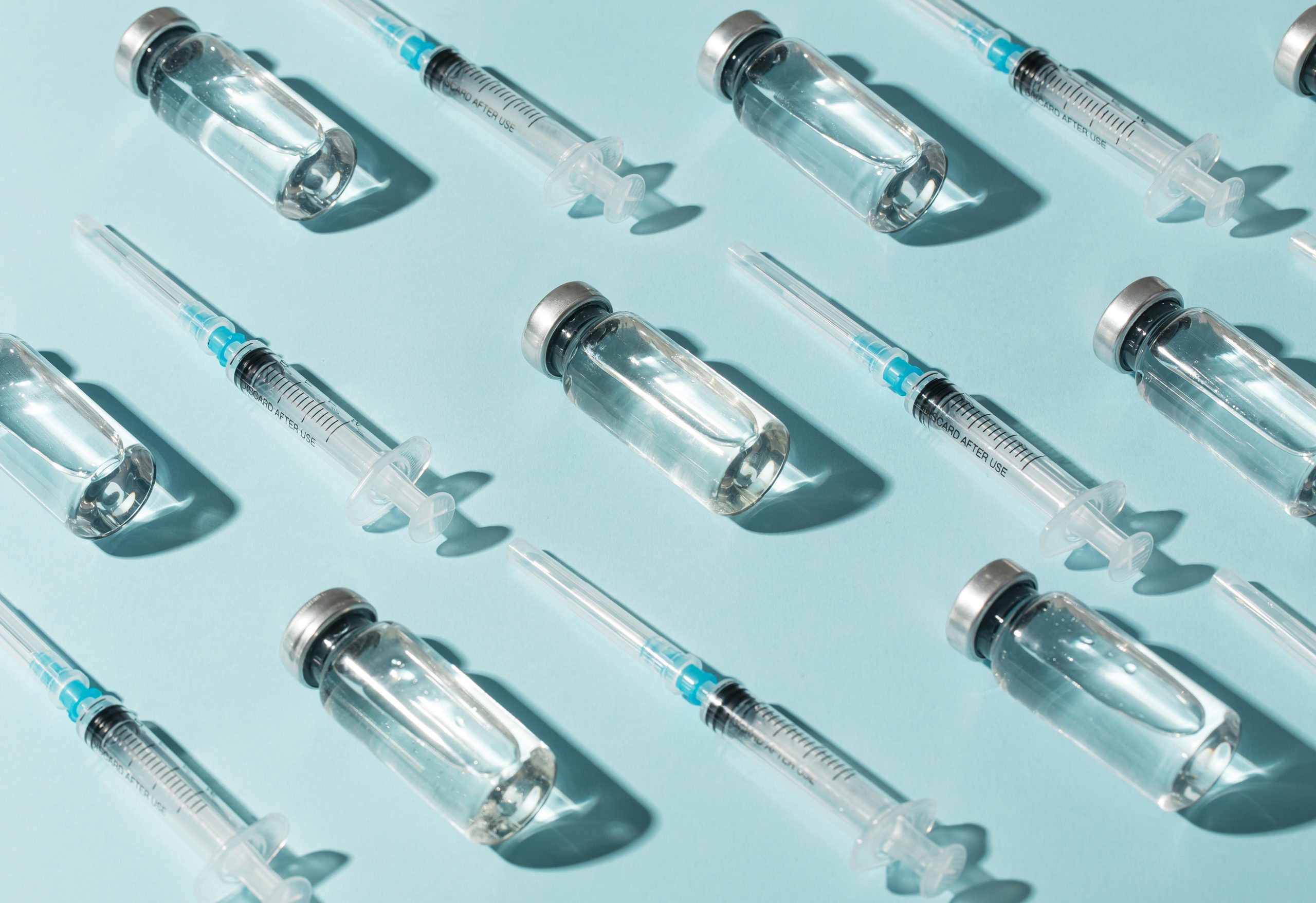 Ilustrační fotografie zobrazující vícero láhviček a stříkaček představující různé typy očkovacích látek.