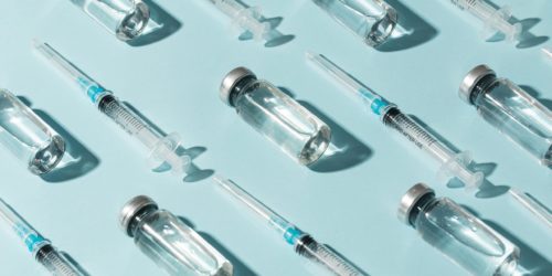 Ilustrační fotografie zobrazující vícero láhviček a stříkaček představující různé typy očkovacích látek.